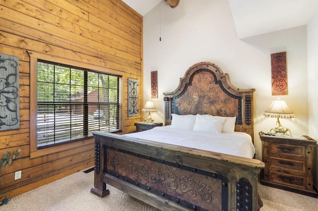 bedroom with wood walls, high vaulted ceiling, and carpet floors