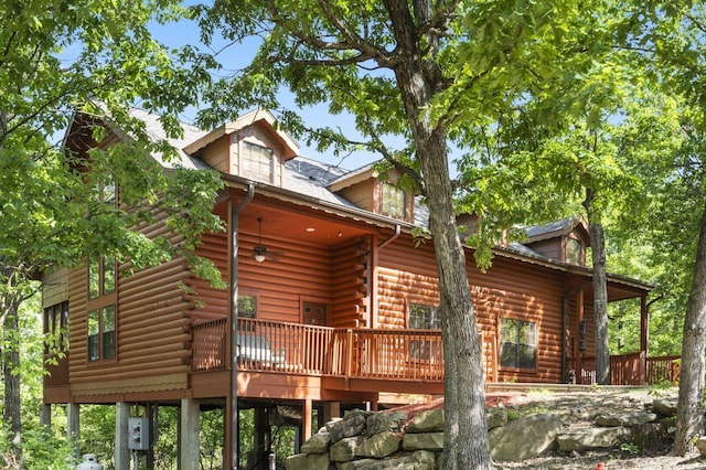 back of house featuring log exterior and a wooden deck