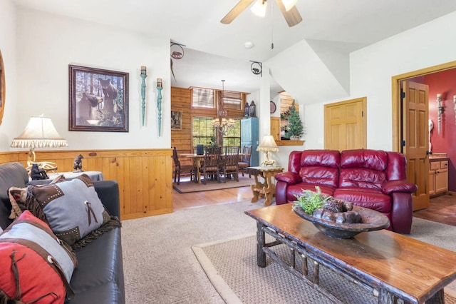 living room with carpet flooring, wooden walls, and a ceiling fan