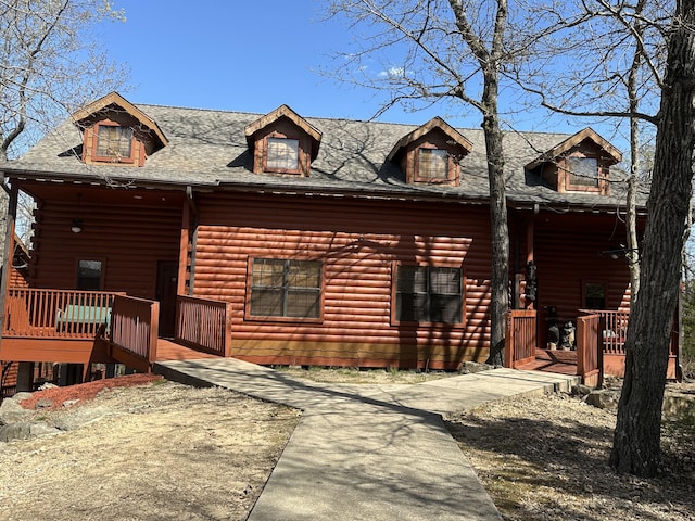 log cabin featuring roof with shingles and a porch