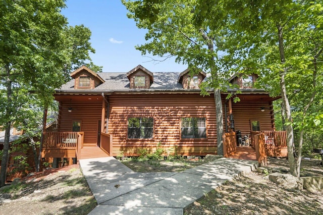 view of front of home with a wooden deck and log exterior
