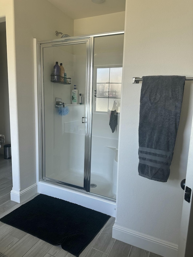 full bath with baseboards and a stall shower
