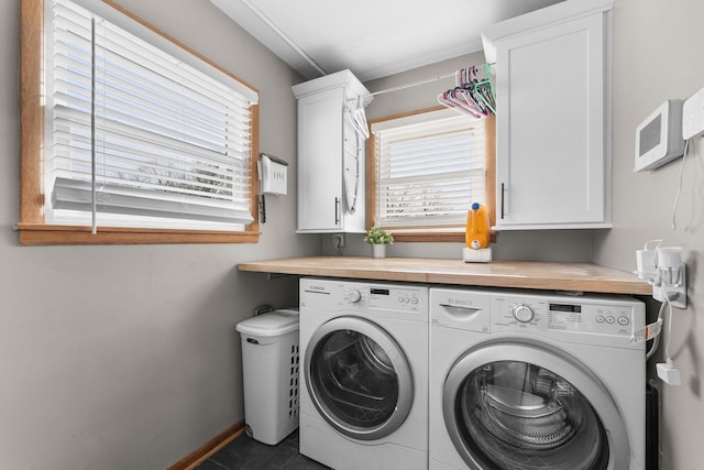 laundry area featuring washer and dryer, baseboards, and cabinet space