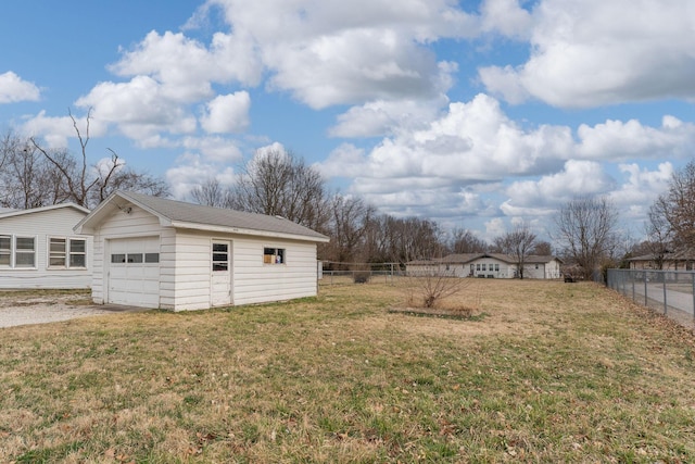 view of yard with driveway, a garage, and fence
