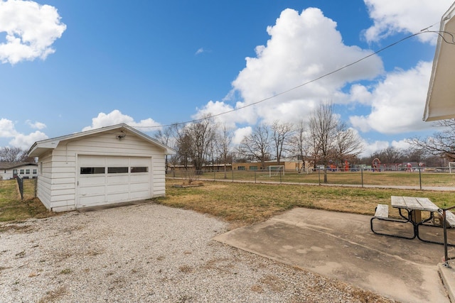 detached garage featuring gravel driveway and fence