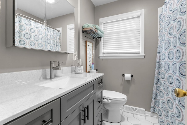 bathroom featuring vanity, baseboards, tile patterned floors, toilet, and visible vents