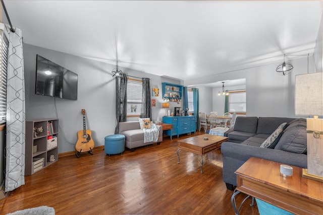 living room with wood finished floors and a notable chandelier
