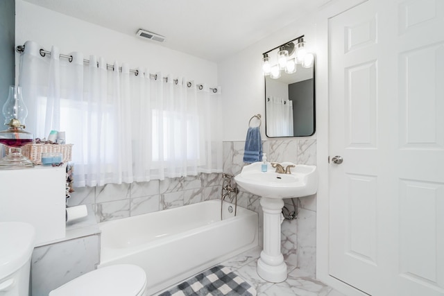 bathroom featuring visible vents, a bath, tile walls, toilet, and marble finish floor