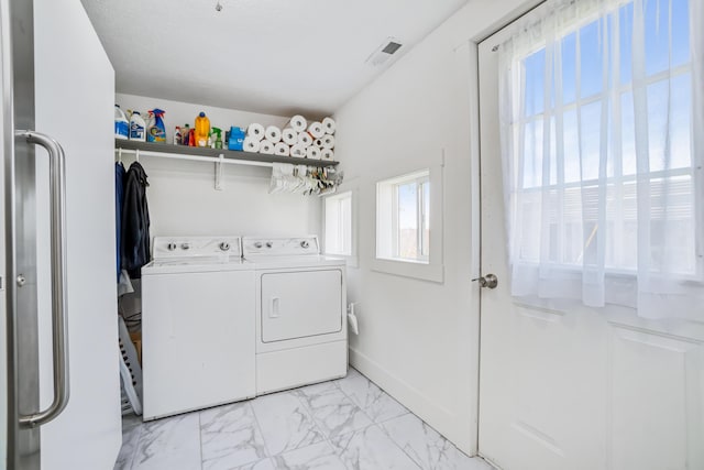 washroom featuring independent washer and dryer, marble finish floor, visible vents, and laundry area