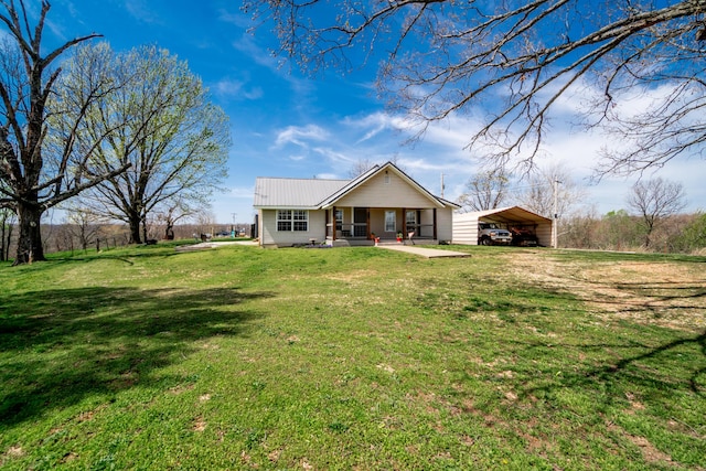 rear view of house with a carport, a yard, metal roof, and covered porch