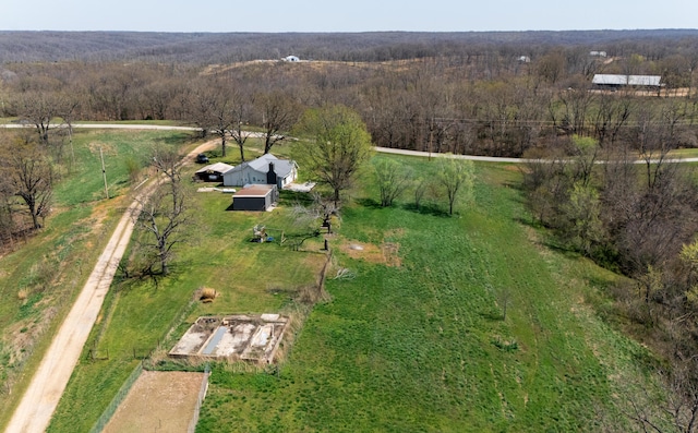 birds eye view of property featuring a view of trees and a rural view