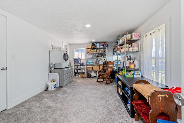 recreation room with recessed lighting, carpet, stacked washer / drying machine, and a textured ceiling
