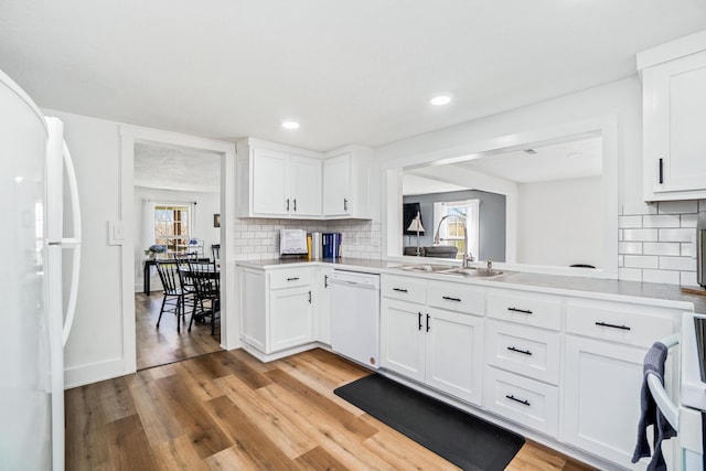 kitchen with white appliances, light countertops, a sink, and light wood finished floors