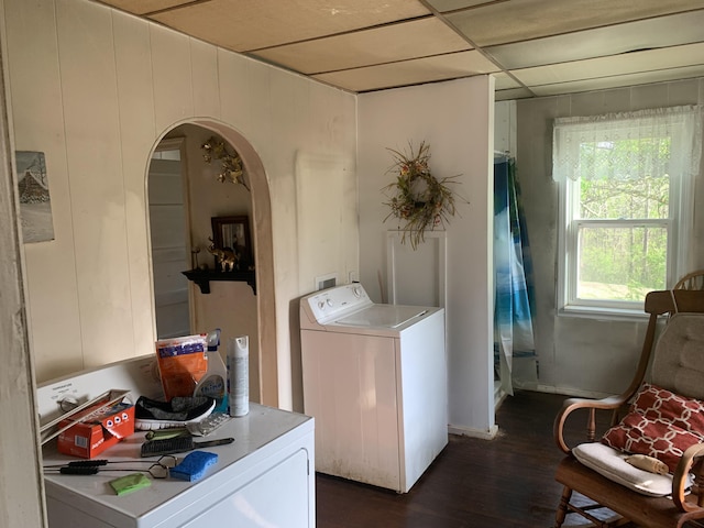 laundry area featuring arched walkways, washer and dryer, dark wood-style floors, and laundry area