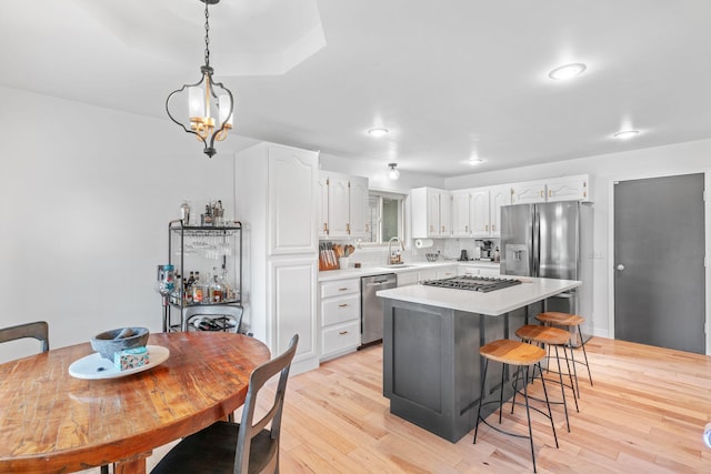 kitchen featuring light countertops, appliances with stainless steel finishes, a sink, and white cabinets