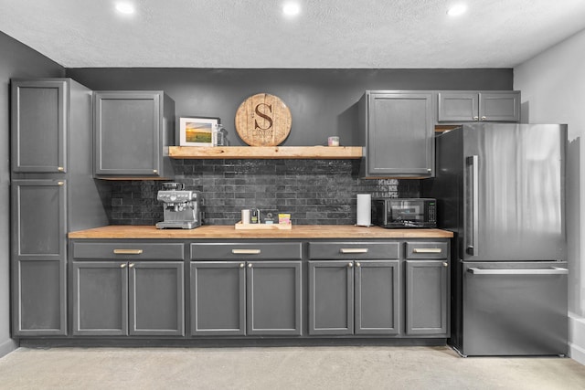 kitchen featuring gray cabinets, wooden counters, freestanding refrigerator, and open shelves