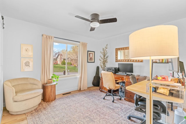 home office featuring visible vents, a ceiling fan, and wood finished floors