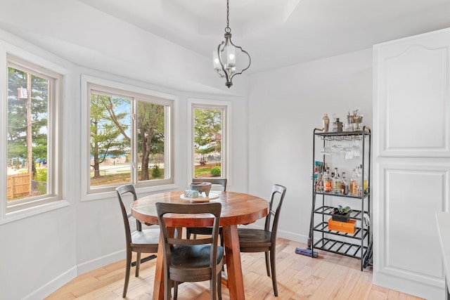 dining space with a notable chandelier, light wood-type flooring, and baseboards
