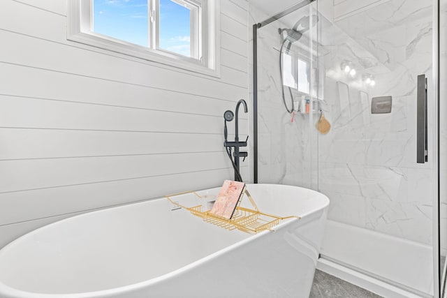 full bathroom featuring a shower stall, plenty of natural light, and a soaking tub