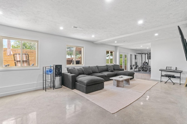 living area featuring concrete floors, visible vents, recessed lighting, and a textured ceiling