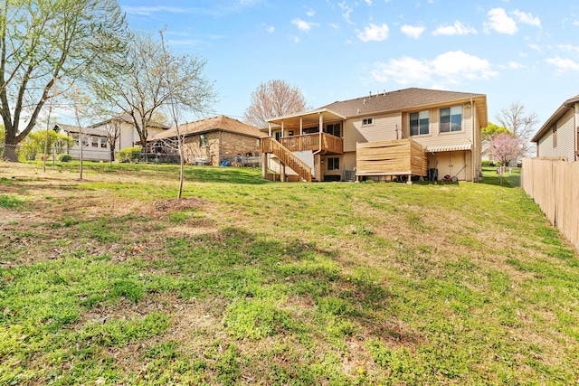 back of property featuring a yard, a wooden deck, a fenced backyard, and stairs