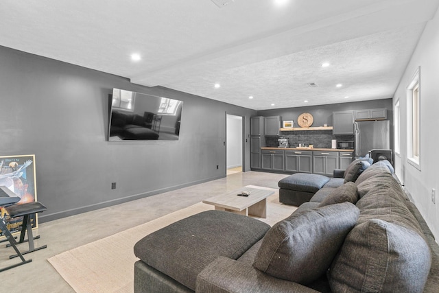 living area featuring a textured ceiling, baseboards, and recessed lighting