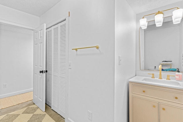 bathroom featuring a textured ceiling, vanity, and baseboards