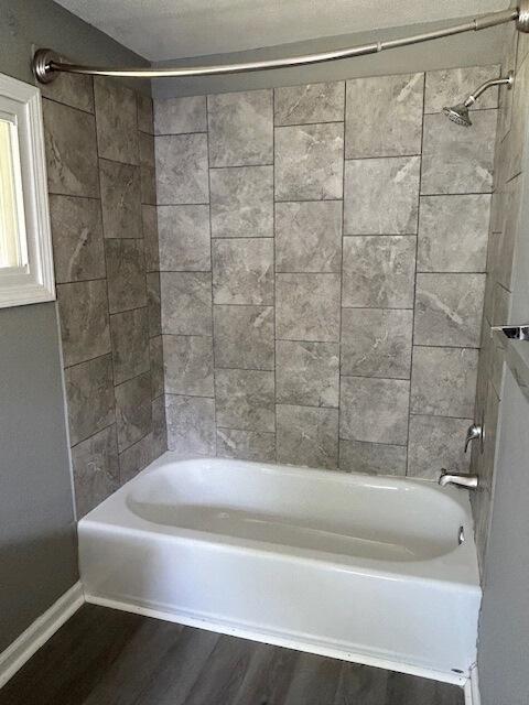 full bath featuring shower / bathtub combination and wood finished floors