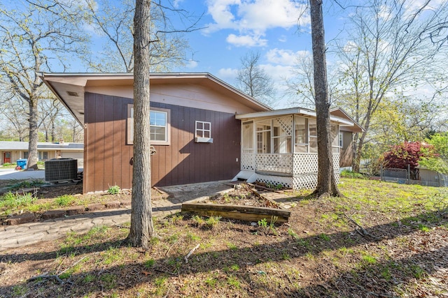 view of side of property with central AC unit and a sunroom