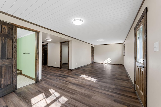 empty room featuring wood finished floors, baseboards, and wooden ceiling