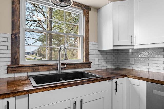 kitchen with decorative backsplash, wooden counters, dishwasher, and a sink