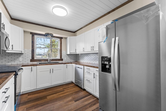 kitchen with crown molding, wooden counters, dark wood-type flooring, appliances with stainless steel finishes, and a sink