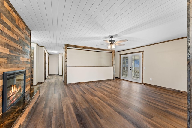 unfurnished living room with a stone fireplace, crown molding, and wood finished floors