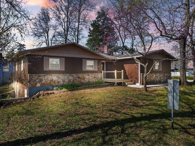 view of front facade featuring a front yard and stone siding