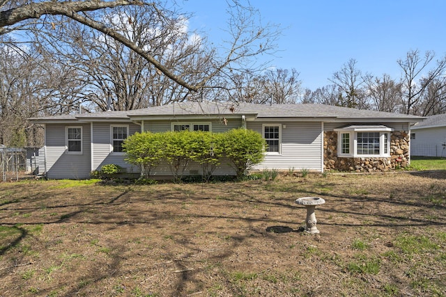 view of front facade with stone siding and fence