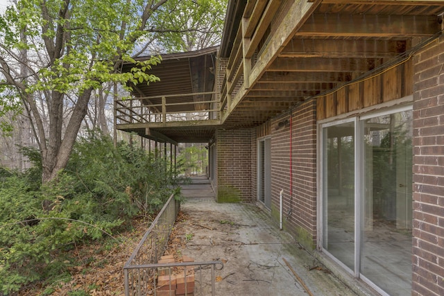 view of side of property featuring brick siding and a balcony