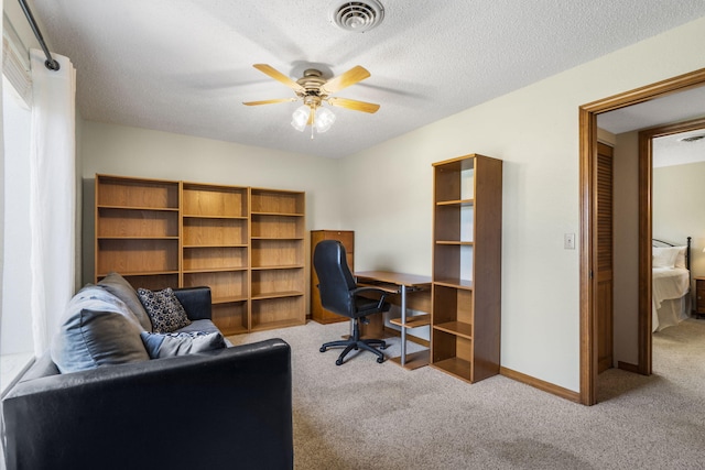 office area with carpet flooring, visible vents, baseboards, and ceiling fan