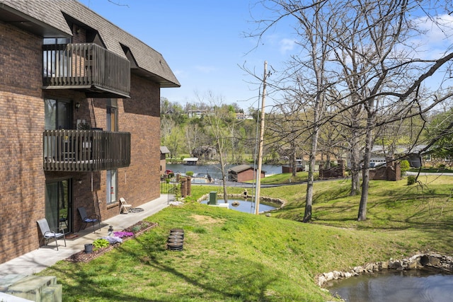 view of yard with a water view and a balcony