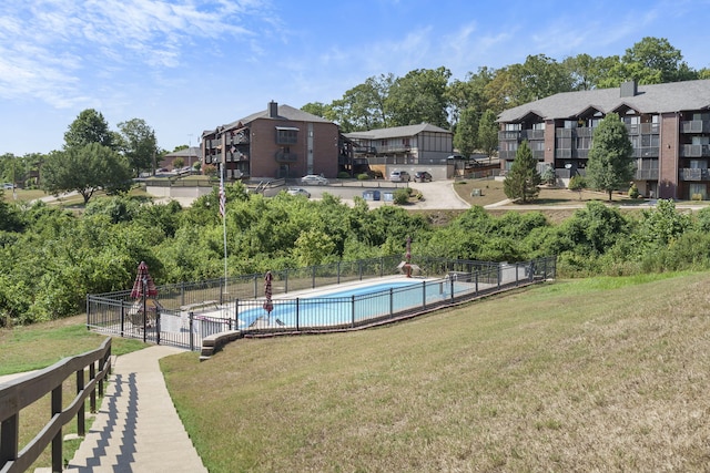 pool featuring fence and a lawn