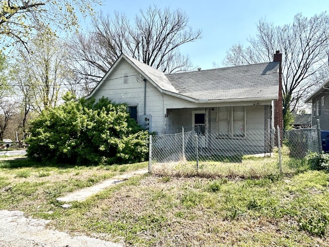 view of home's exterior with roof with shingles, a chimney, and a fenced front yard