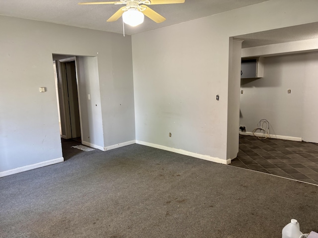 carpeted empty room featuring baseboards and a ceiling fan