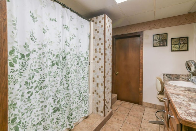 full bath with a paneled ceiling, a shower with shower curtain, tile patterned flooring, and vanity