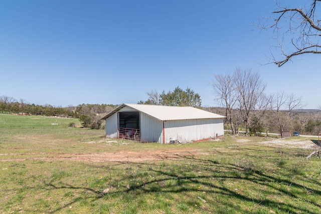 view of pole building with a rural view and a lawn