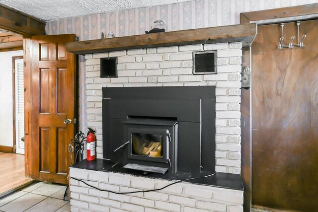 details with a textured ceiling, wallpapered walls, a fire extinguisher, and visible vents