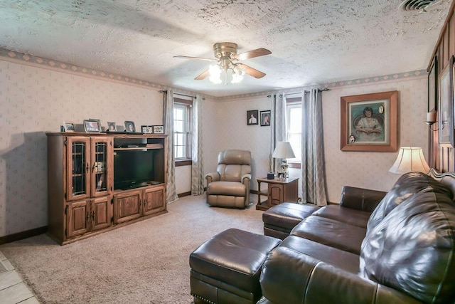 living area featuring wallpapered walls, a textured ceiling, visible vents, ceiling fan, and light colored carpet