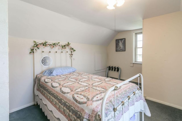 carpeted bedroom with baseboards and vaulted ceiling