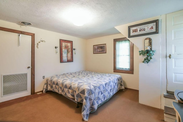 bedroom featuring visible vents, carpet flooring, and a textured ceiling