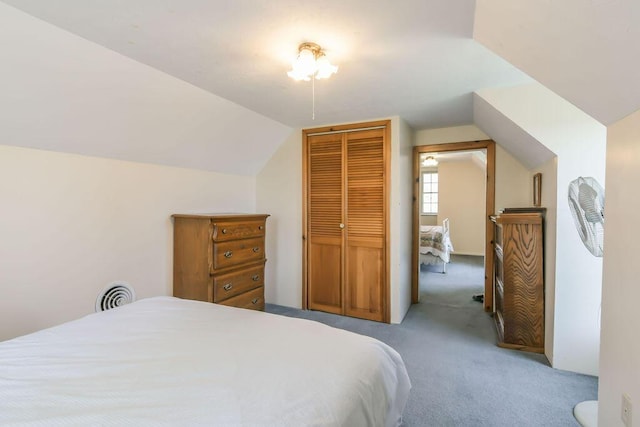 bedroom featuring a closet, visible vents, light colored carpet, and lofted ceiling