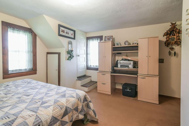 bedroom with a textured ceiling and light colored carpet