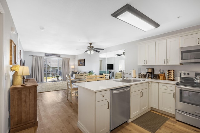 610 Abby Ln Unit 2, Branson, MO 65616 - kitchen featuring a peninsula, appliances with stainless steel finishes, a sink, light countertops, and open floor plan
